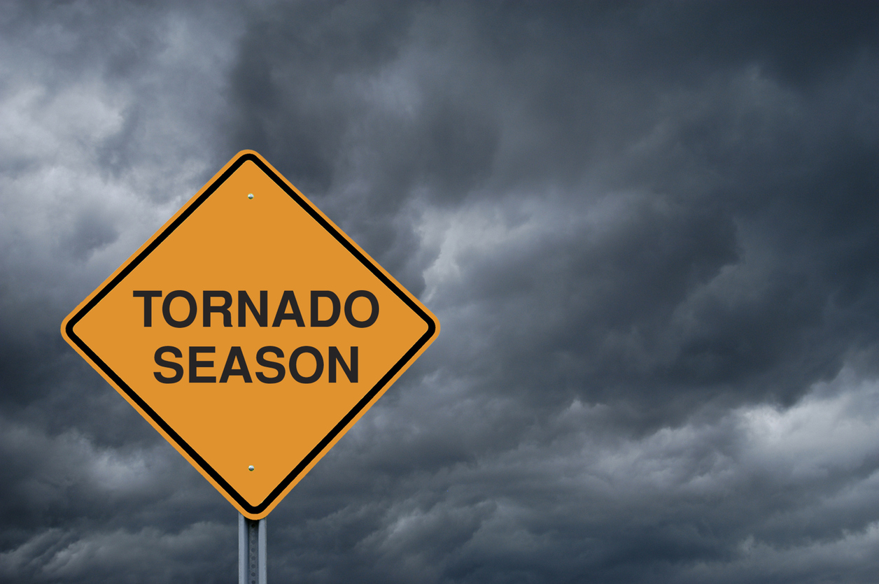 "Tornado season" street sign against a backdrop of threatening, dark clouds.