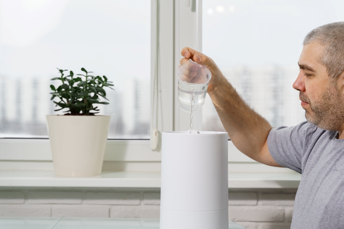uses for hydrogen peroxide - man pouring water solution into humidifier
