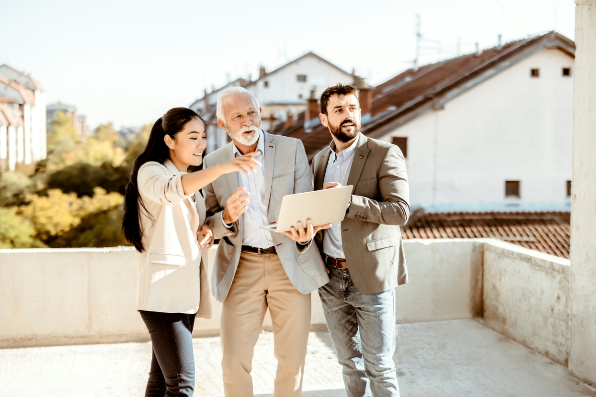 Mixed couple meeting with older real estate agent
