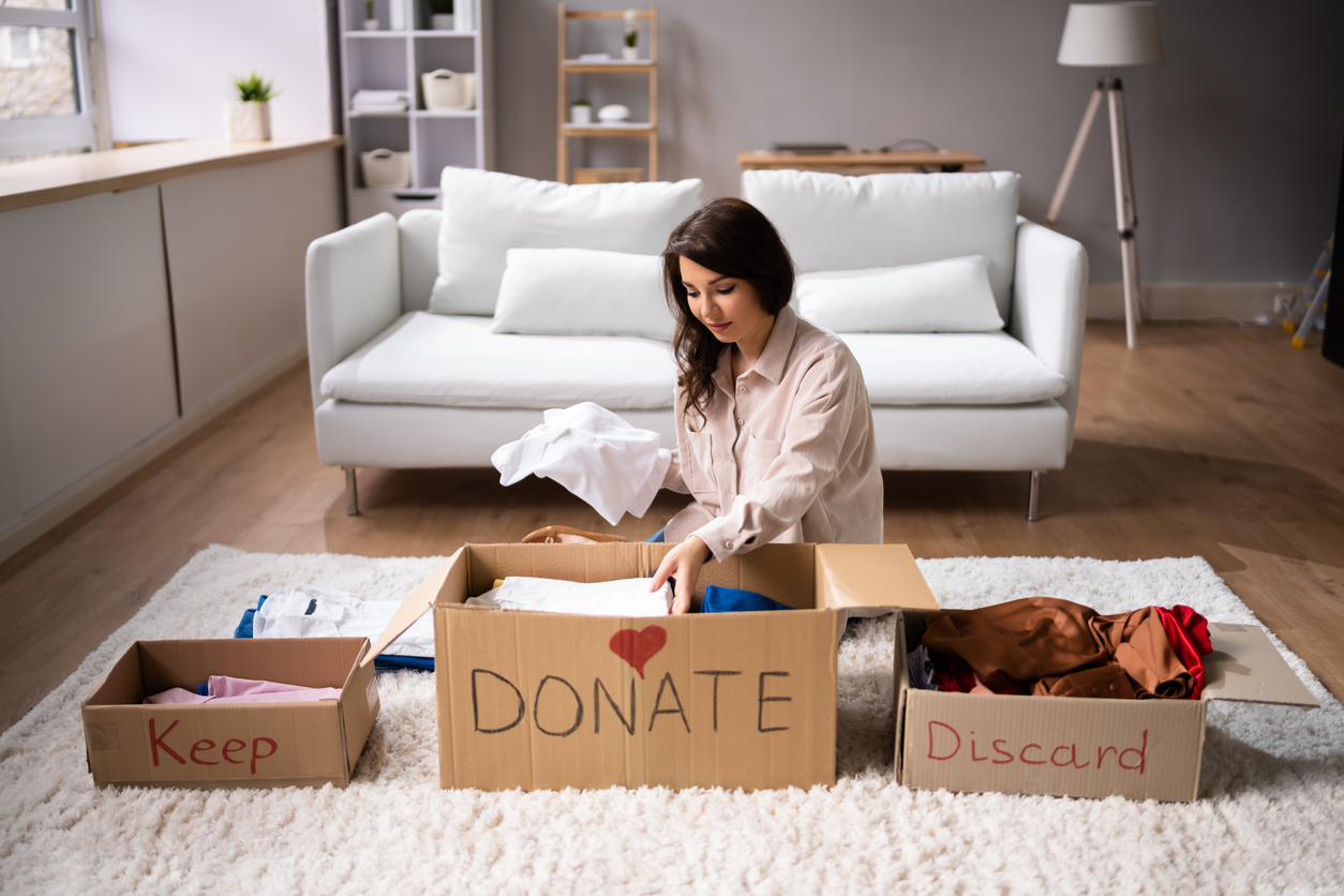 woman in living room sorting belongings for donation
