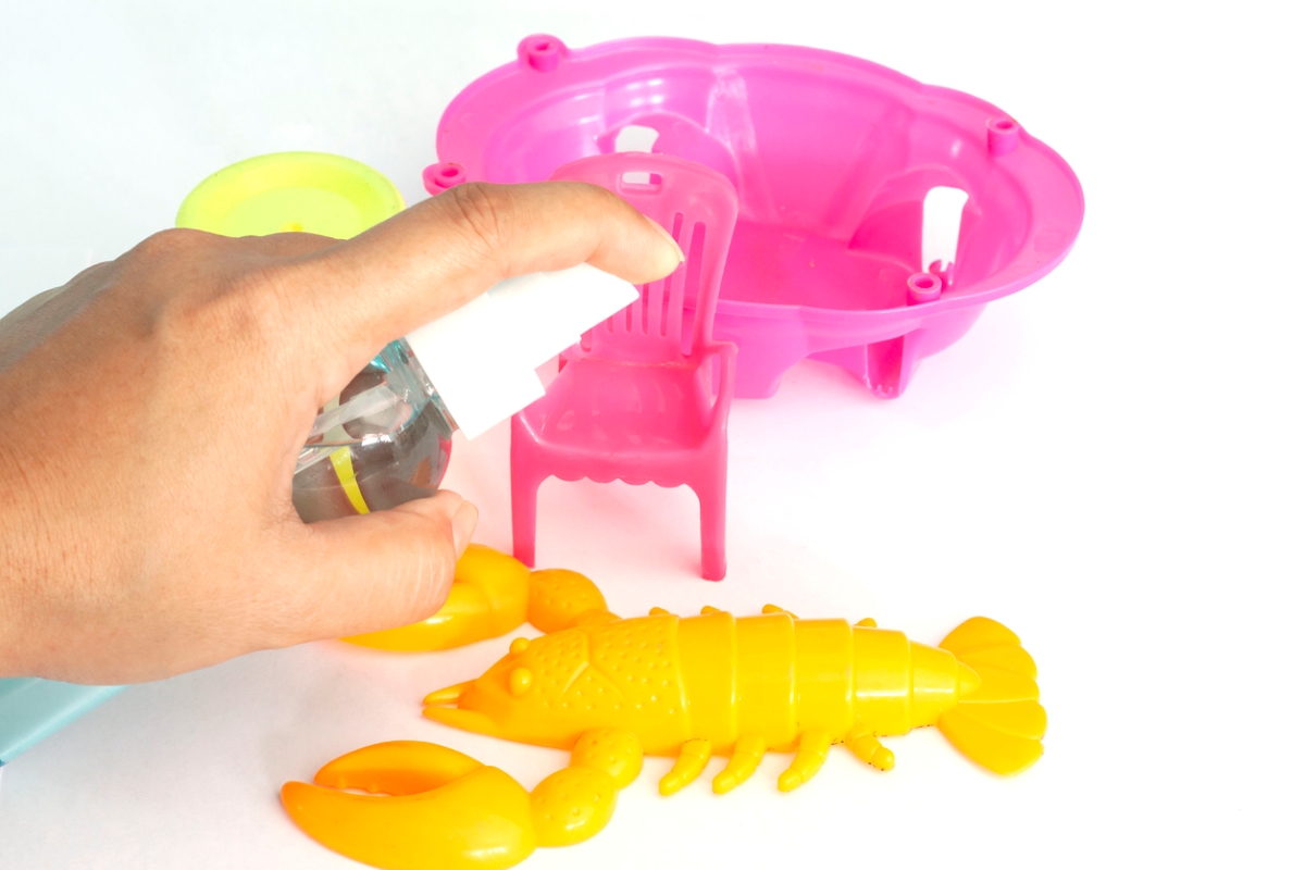 uses for hydrogen peroxide - spraying cleaning solution on kids toys