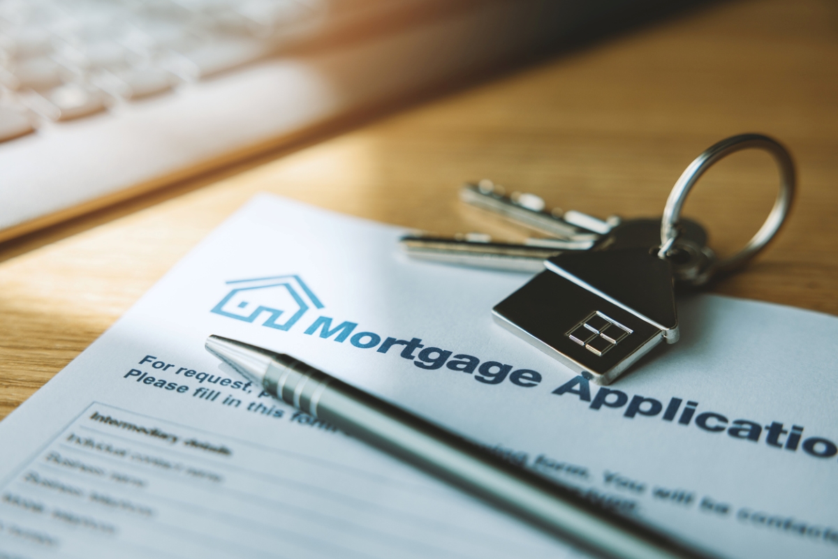 how to choose a rental property - keys and pen on mortgage application