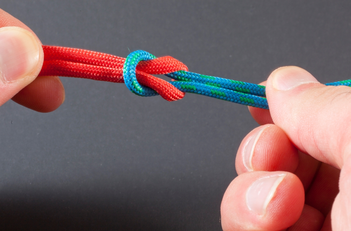 Person practicing tying knots with paracord