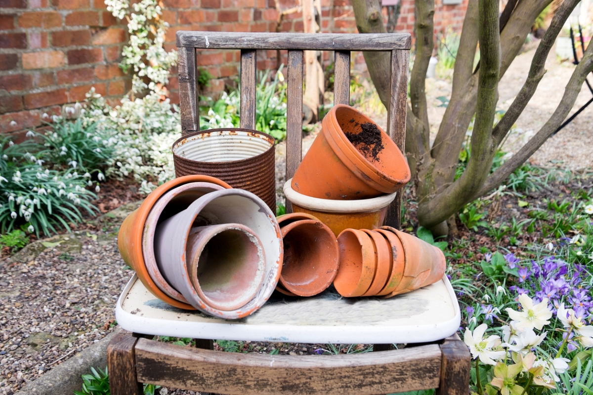 uses for hydrogen peroxide - pile of old garden pots on chair in a garden