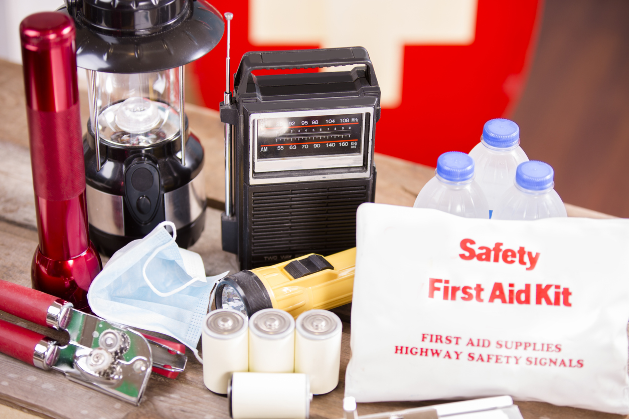 Emergency preparedness supplies, including a first aid kit, can opener, flashlights, and radio.