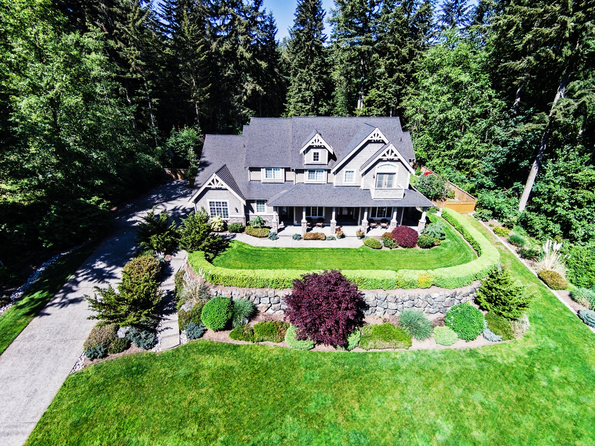 aerial view luxury home surrounded by trees large landscaped lawn