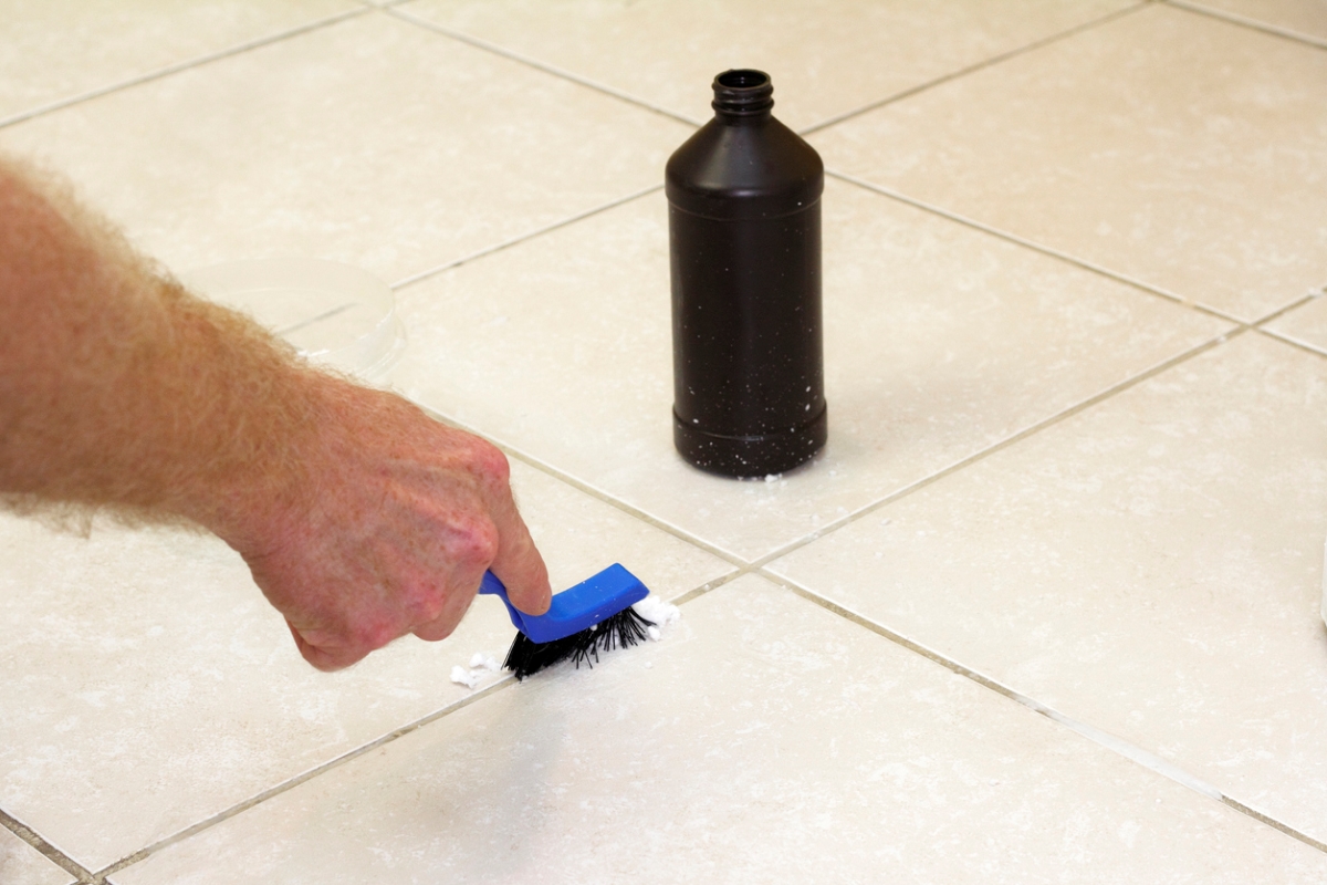 uses for hydrogen peroxide - hand scrubbing tile with cleaning tool