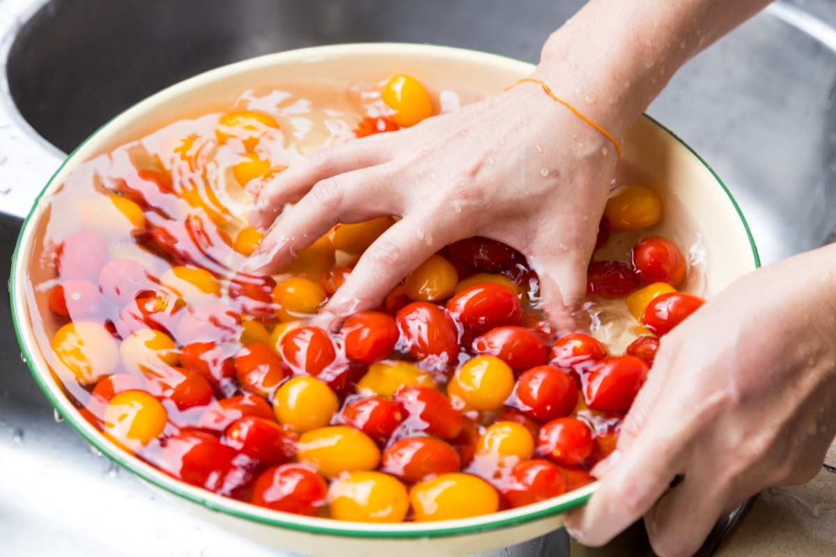 uses for hydrogen peroxide - hand swishing cherry tomatoes in water