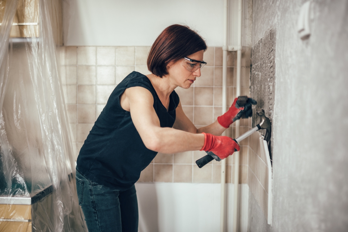 Woman tearing bathroom tile
