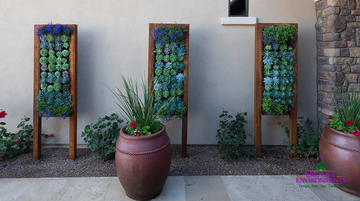 outdoor entryway with succulent planter frames standing vertically against an exterior wall
