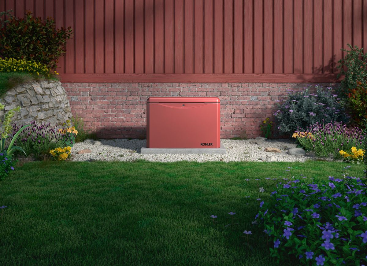 Kohler 26kW RCA generator in red against a red cedar fence wall