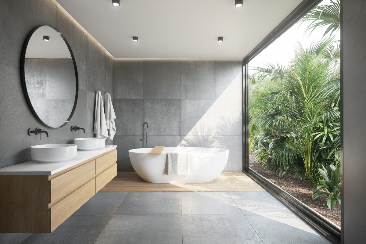 A modern bathroom with a concrete floor and a large window.
