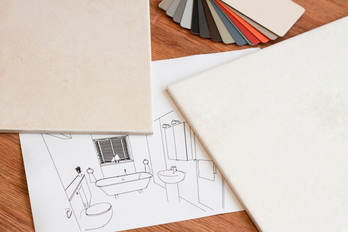 Flooring samples, a bathroom sketch, and color swatches on a wood table