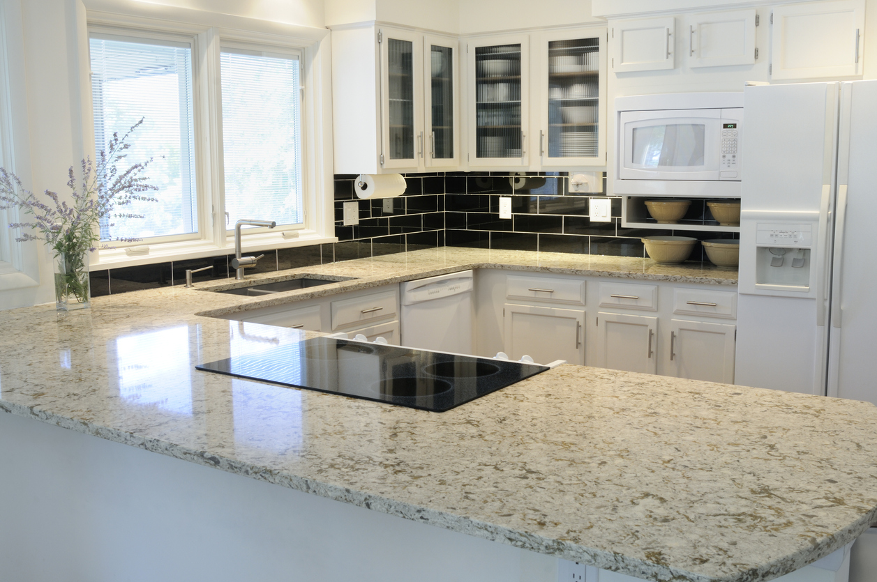 Bright kitchen with white cabinets, white appliances, and a contrasting black tile backsplash