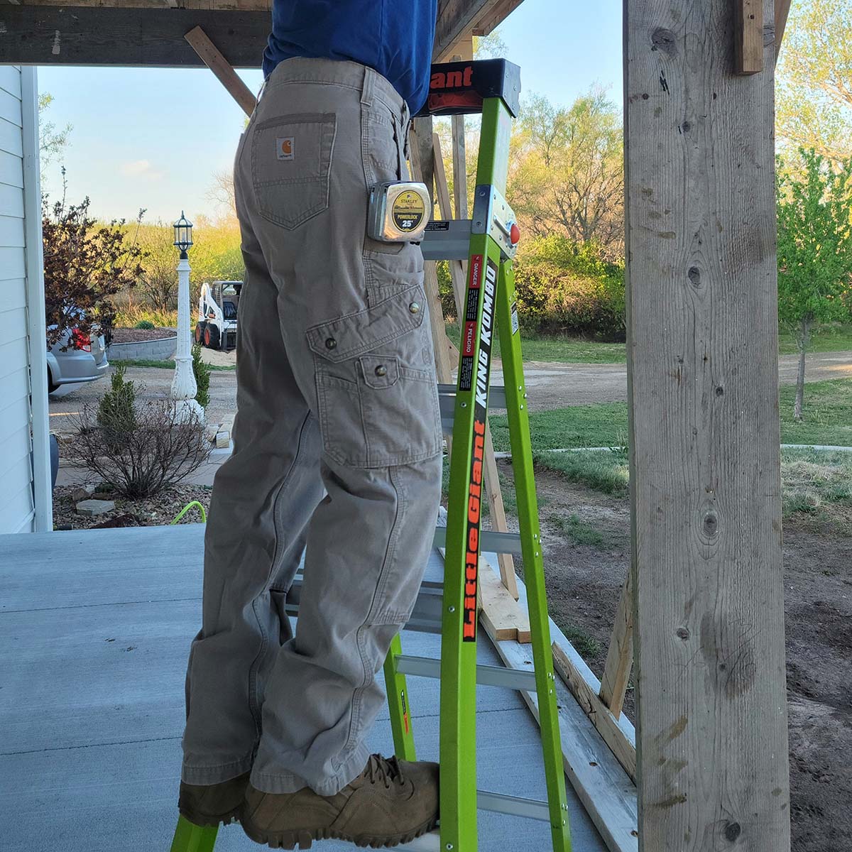 Man in Carhartt Cargo Pants standing on yellow ladder
