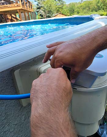 A person setting up the Dolphin Escape robotic pool cleaner power adaptor