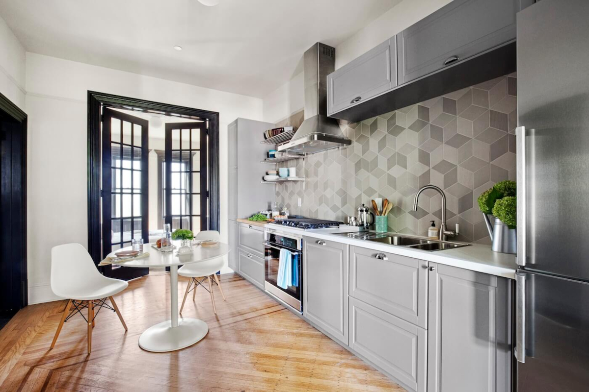 Minimalist kitchen with grayscale rhombile tile backsplash and gray cabinets