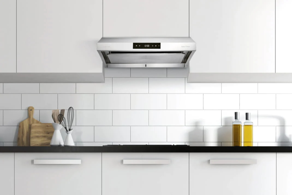 Product render of a stainless steel Hauslane under-cabinet range hood in a bright kitchen