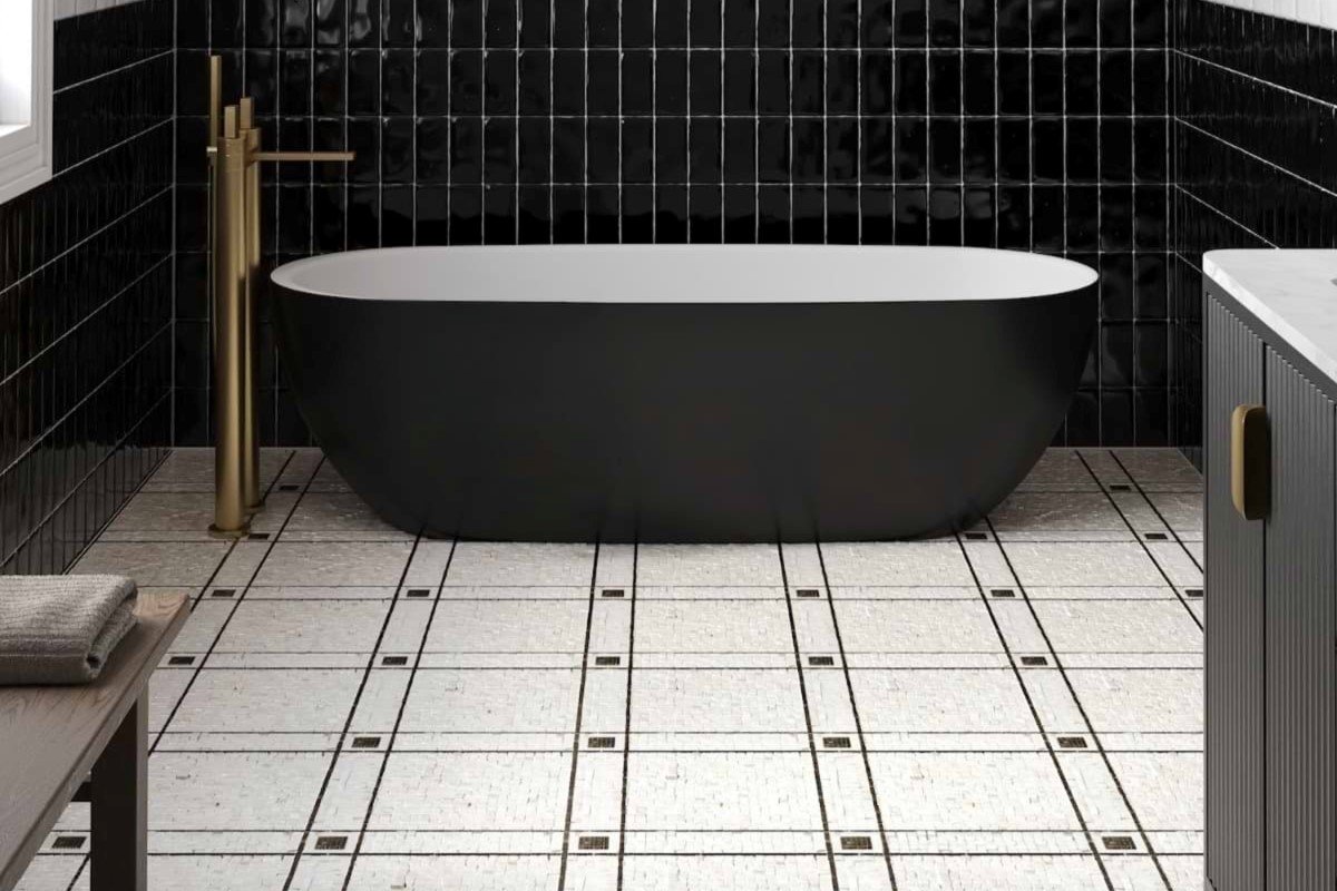 Polished marble mosaic tiles used to create flooring pattern in the bathroom with a dark colored tub.