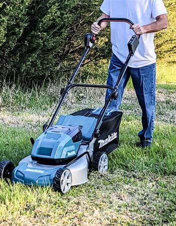 Man mowing grass with Makita 18-inch cordless lawn mower