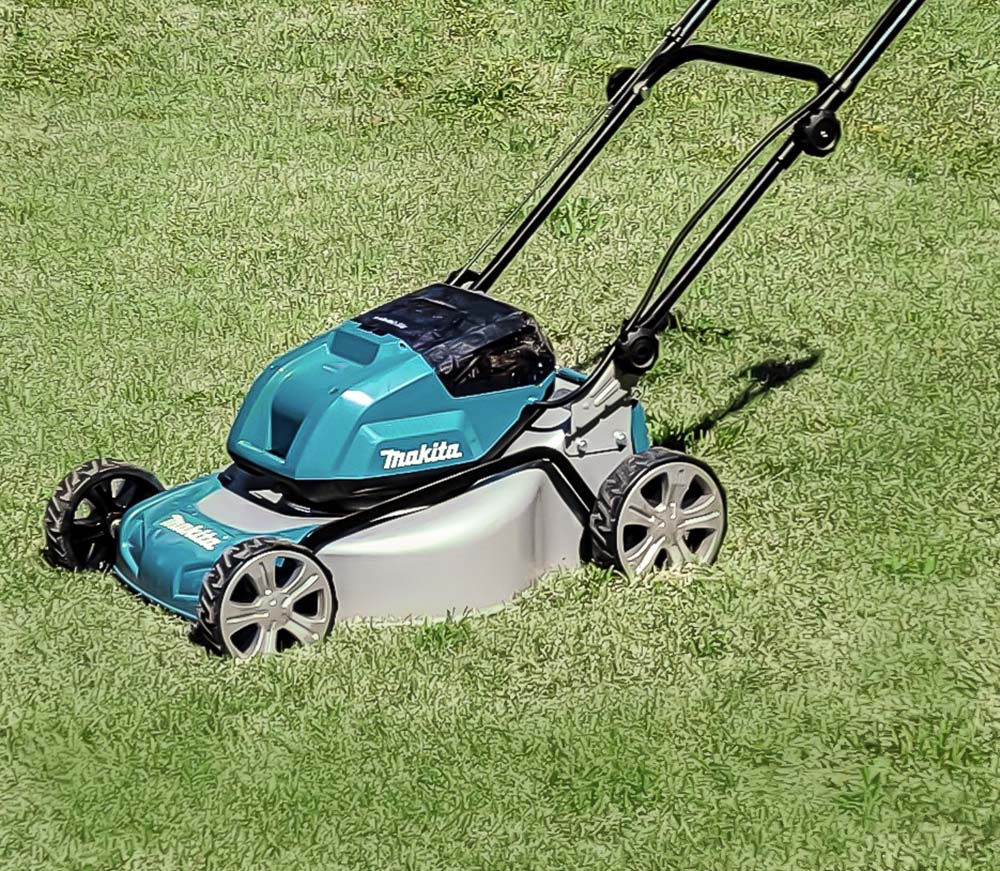 Makita XML03 Brushless Cordless 18-Inch Lawn Mower sitting in grass yard