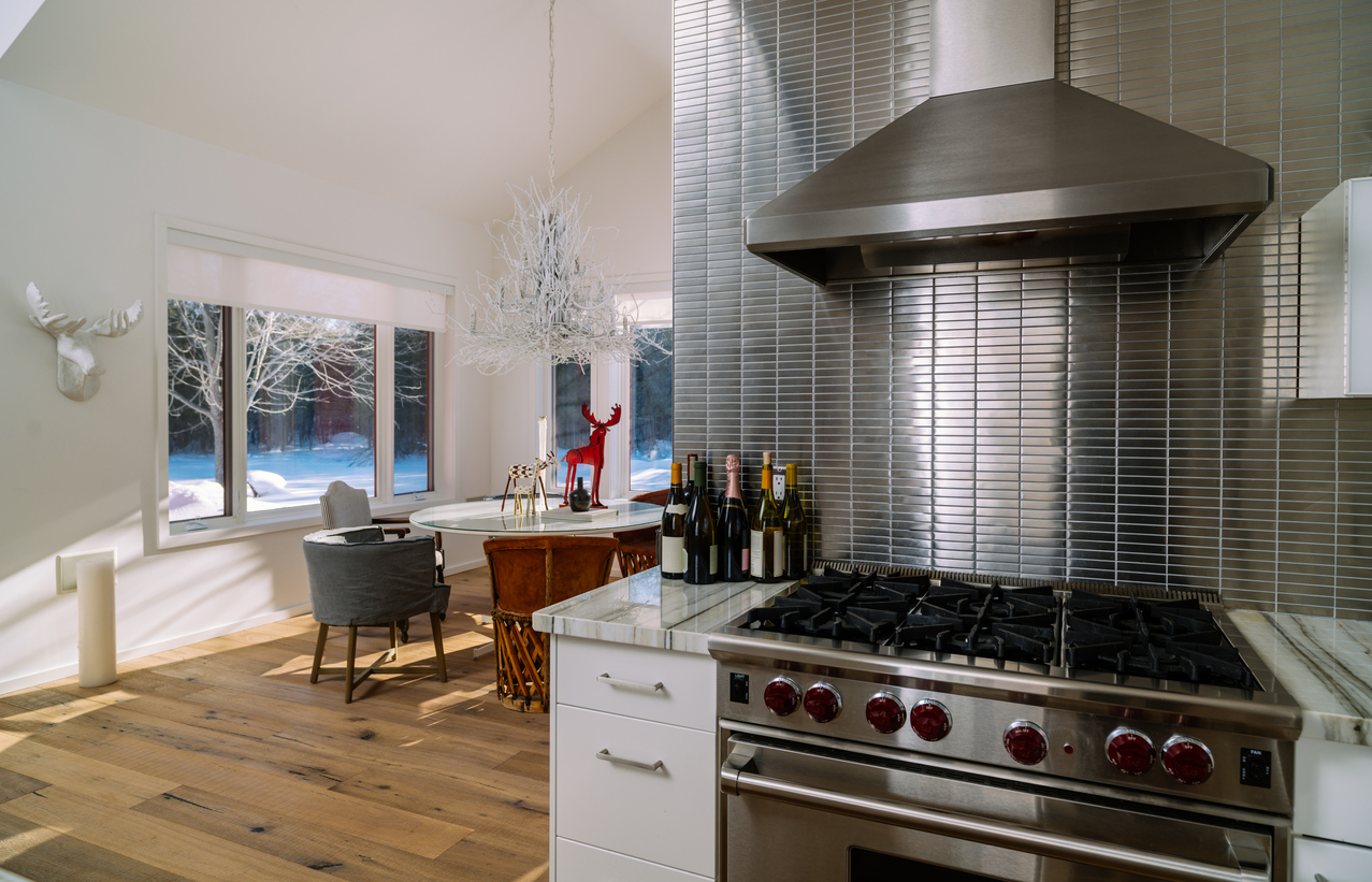 Shiny silver tile kitchen backsplash flanked by an eclectic Scandinavian dining room in winter