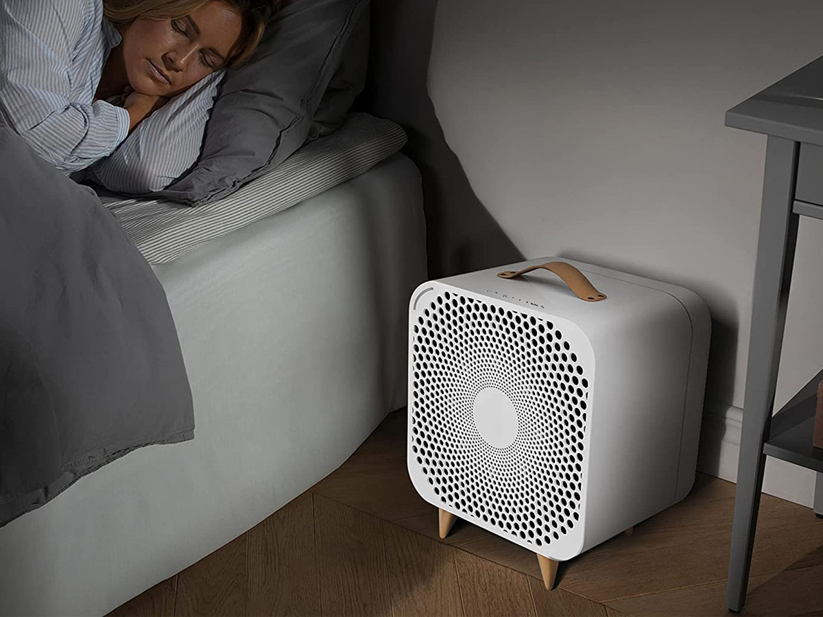 The Best Fans for White Noise Option next to a bed with a sleeping person