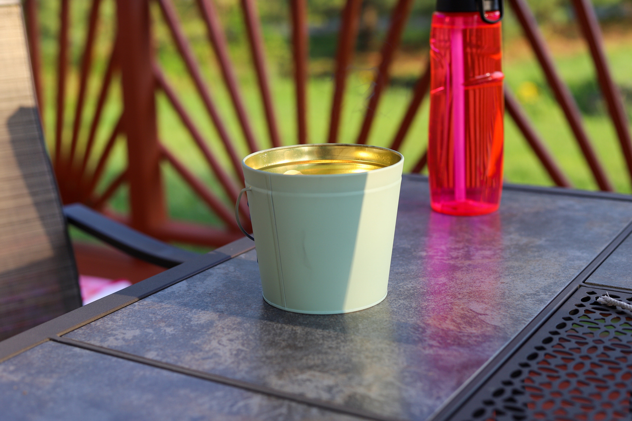A close-up of the best mosquito repellent for patios sitting on a patio table