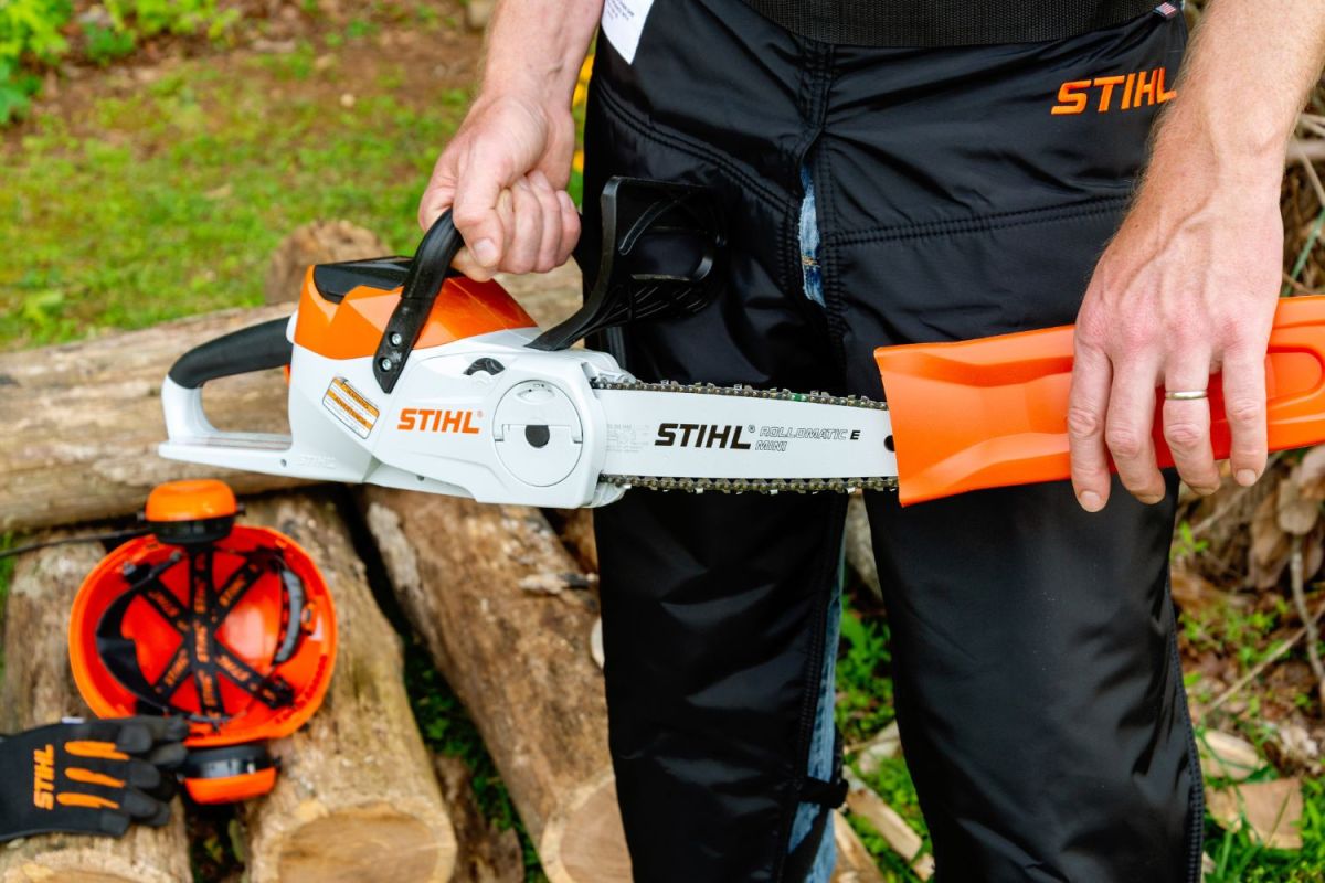 Someone removing the bar guard from the Stihl MSA electric chainsaw