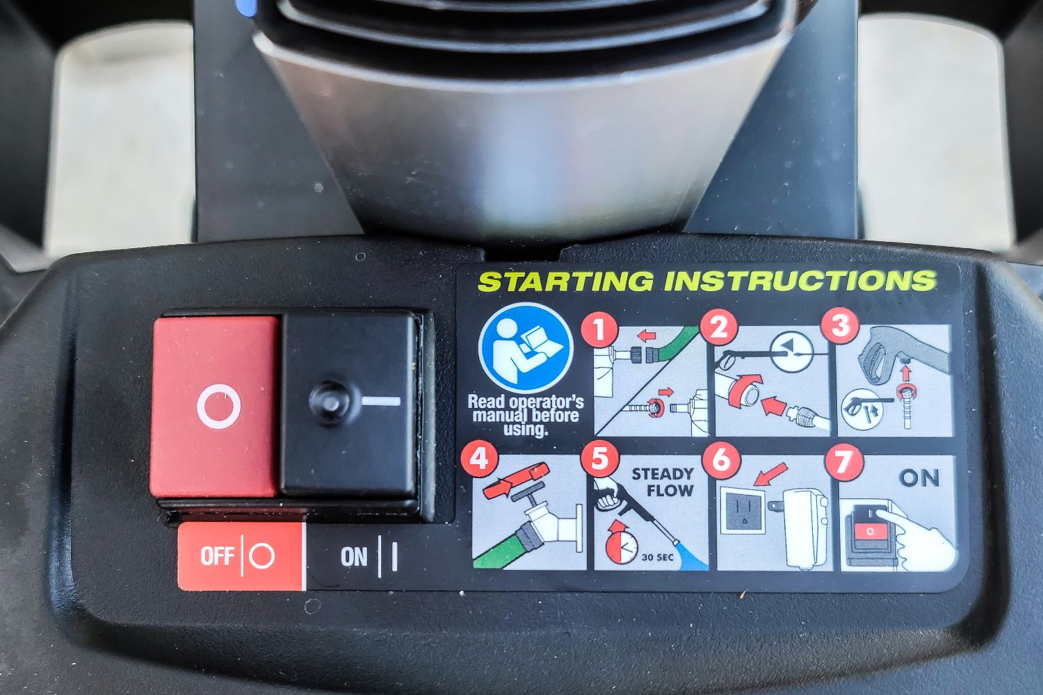 A close-up of the Ryobi pressure washer 2000 PSI's one-touch on/off switch and starting instructions