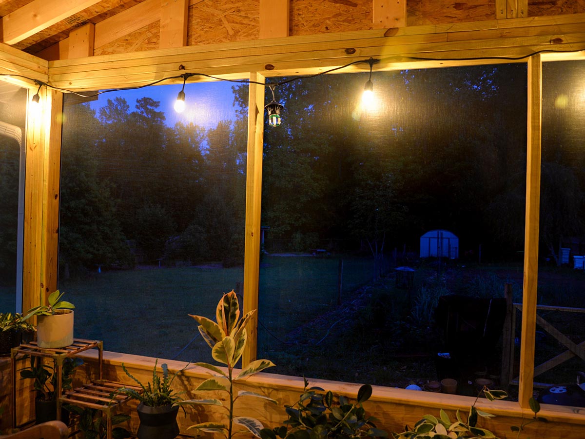 An evening photo of the Tiki BiteFighter LED String Lights illuminating a screened-in porch