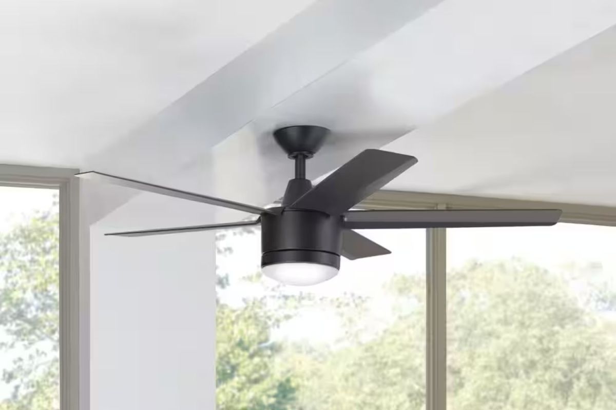 The Best Smart Ceiling Fans Option mounted on a white ceiling with large windows in the background