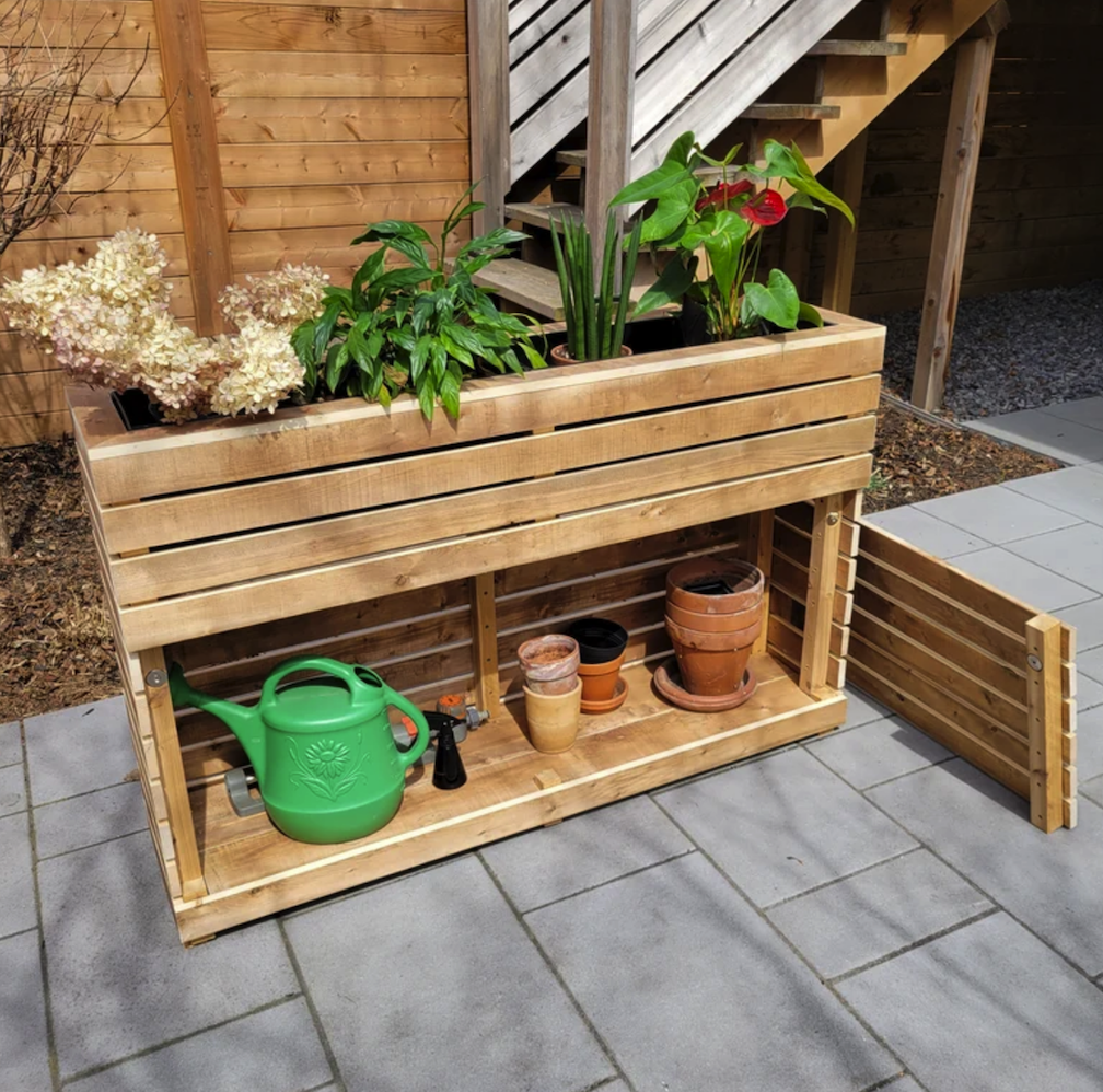 tall rectangular planter box with exposed cabinet containing a watering can and planting pots