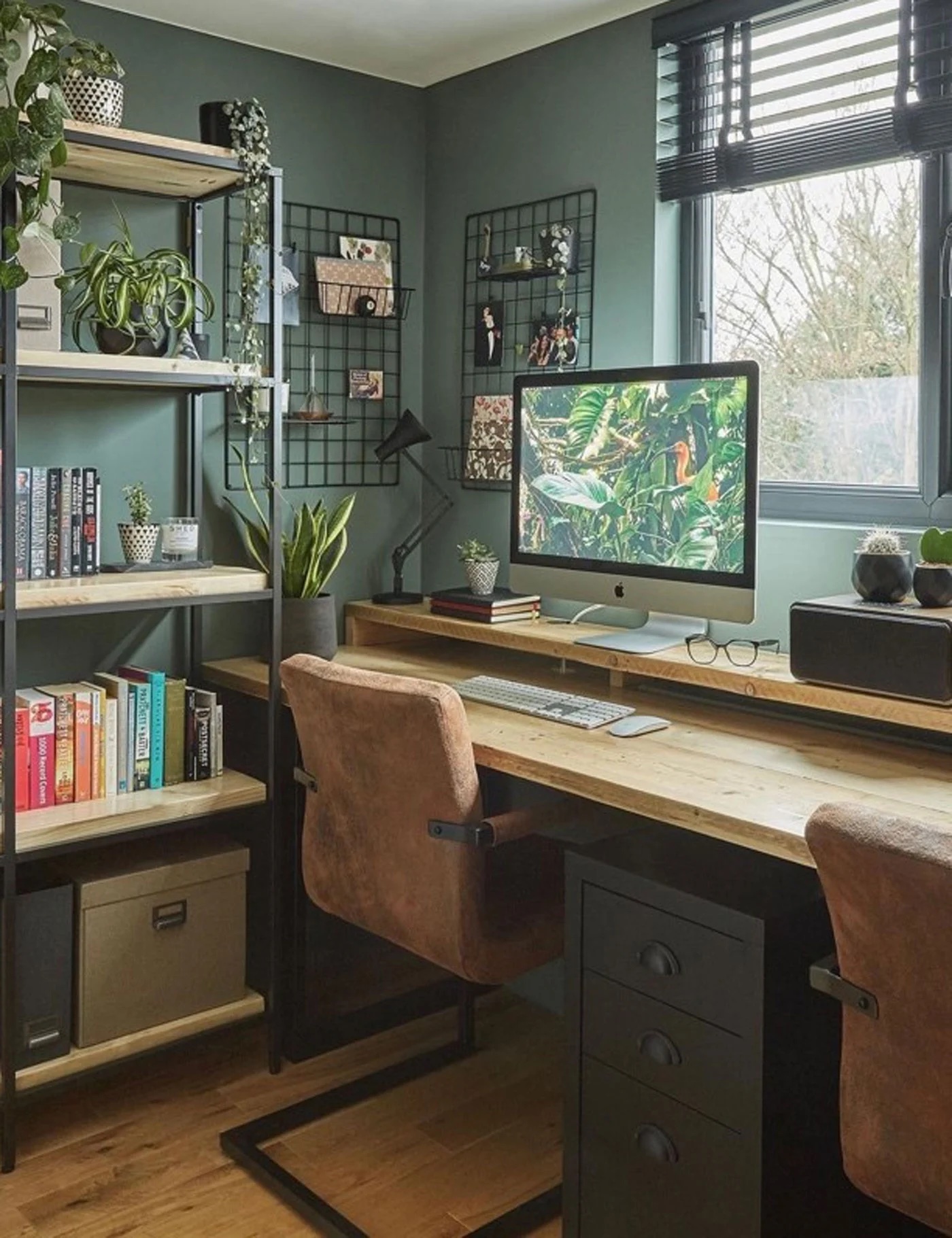 Home office with sage green walls, plants, and earth toned decor