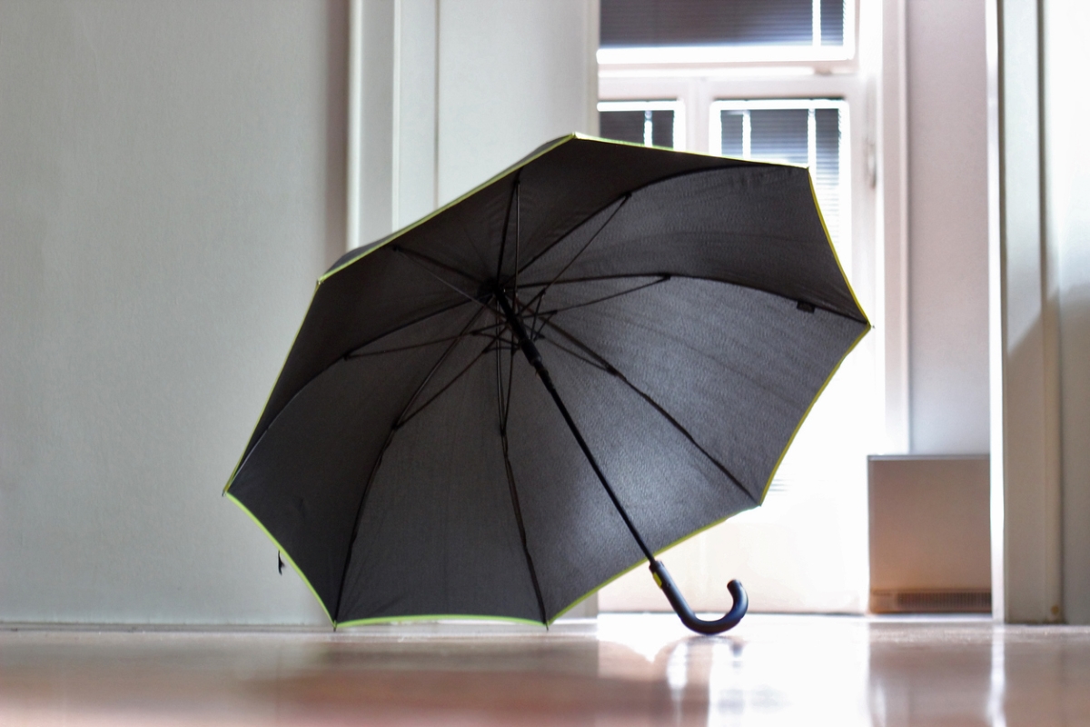 Open black umbrella in home