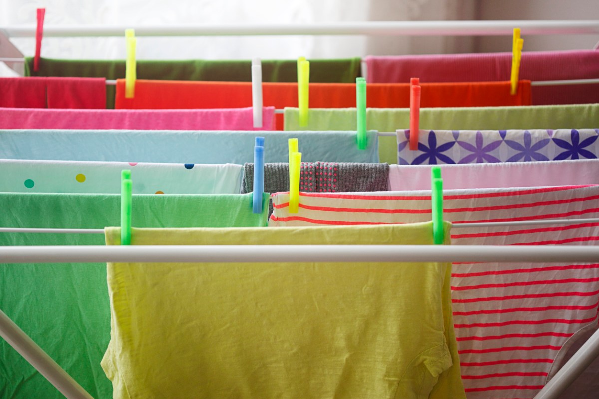 bright colored t-shirts hanging in rows on clotheslines with colorful clothes pins
