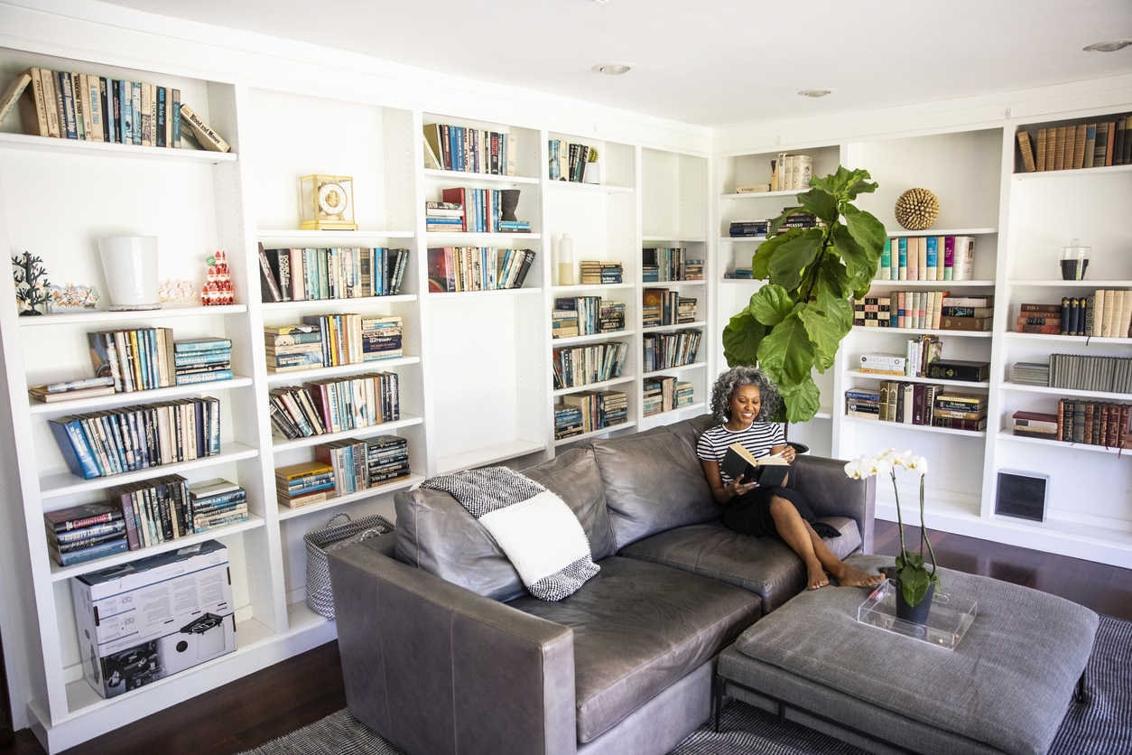 Black Woman Reading a book in her library at home