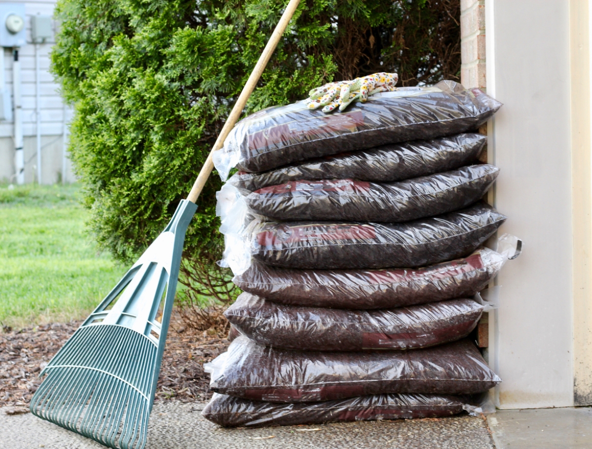Bags of mulch stacked against house