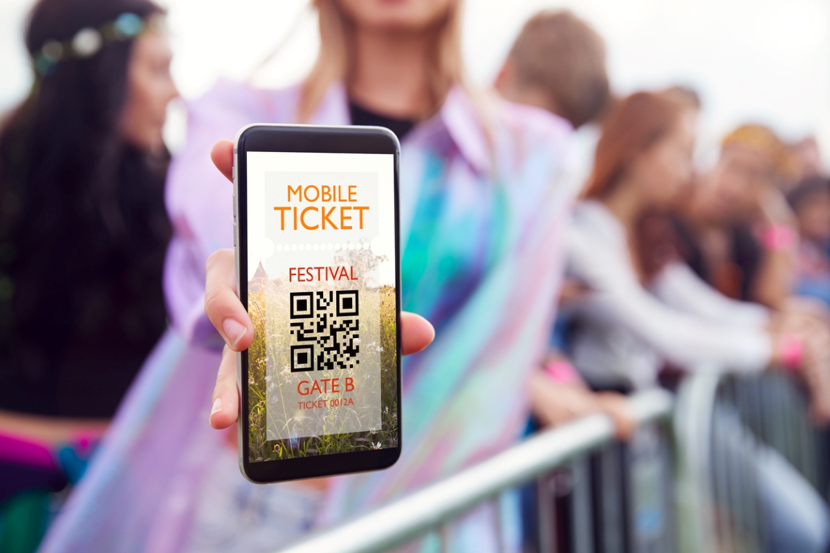 Woman holding phone showing mobile ticket