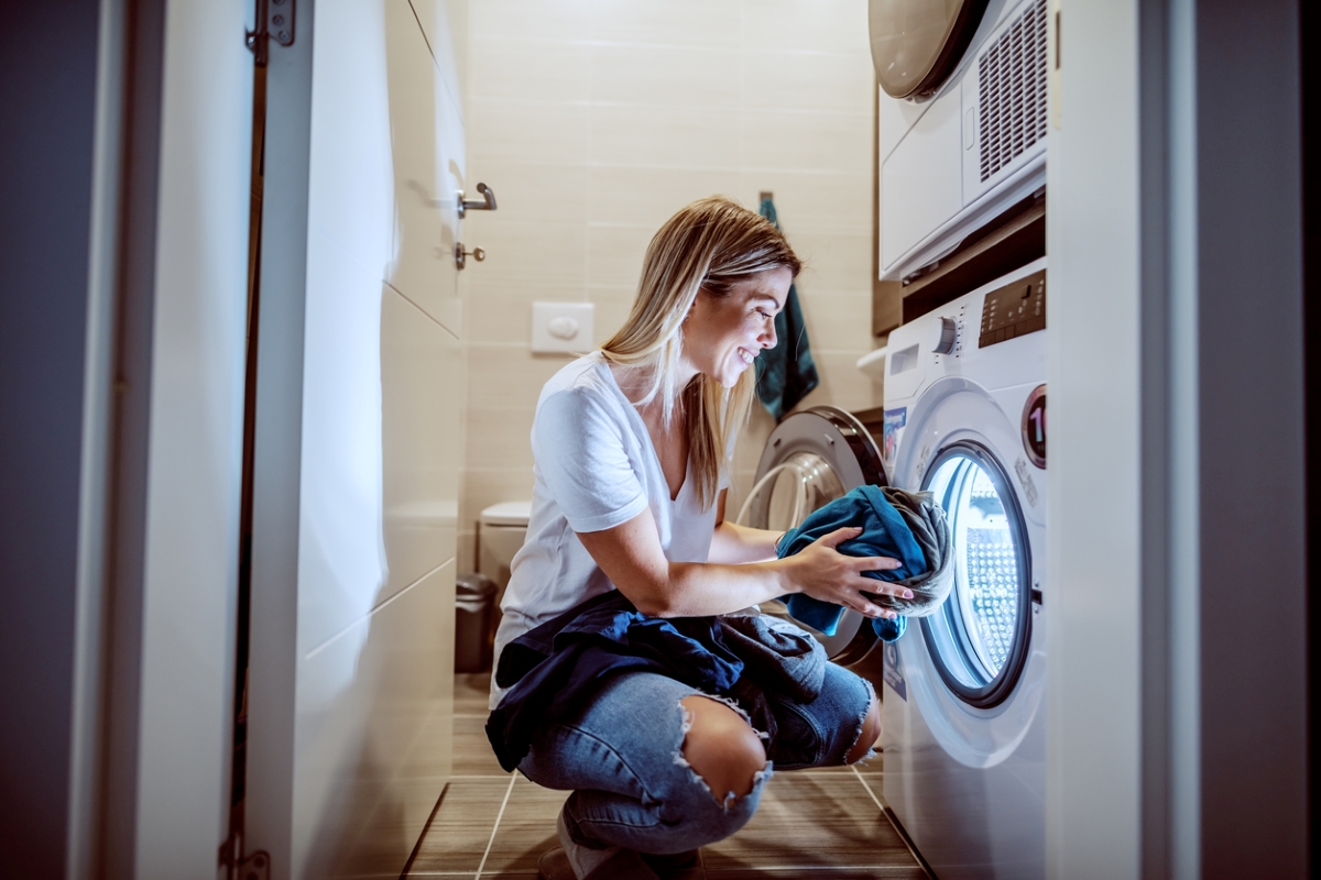 Woman putting clothes in dryer at night