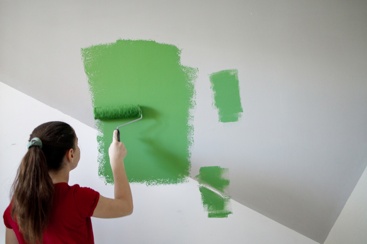 Girl painting wall green