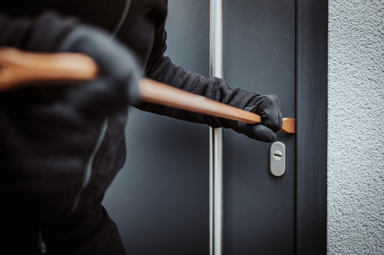Burglar trying to break into black steel door