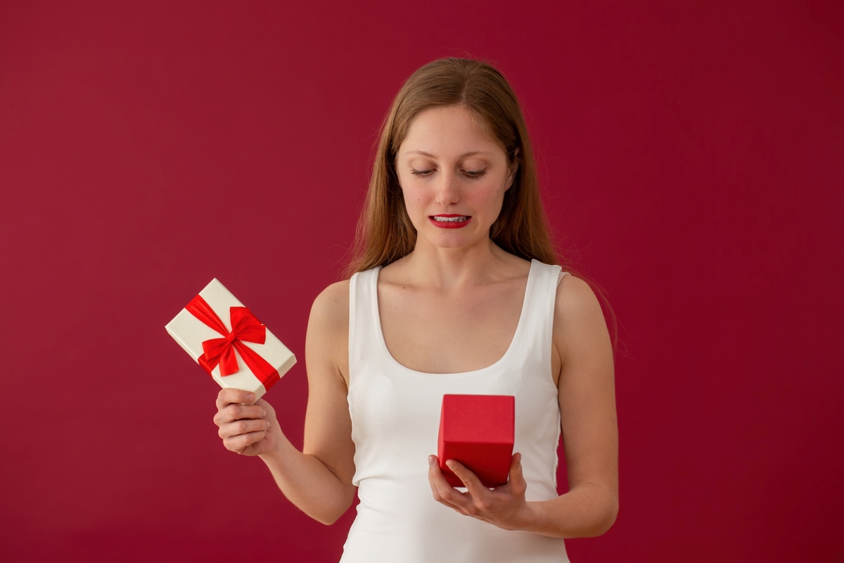 Woman opening gifts with embarrassed look