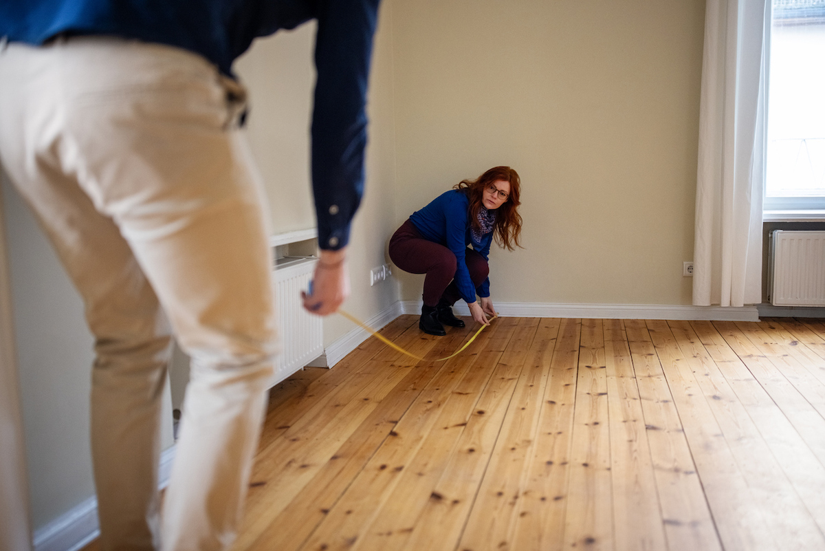 woman measuring the square footage of a room to determine what size mini split it requires