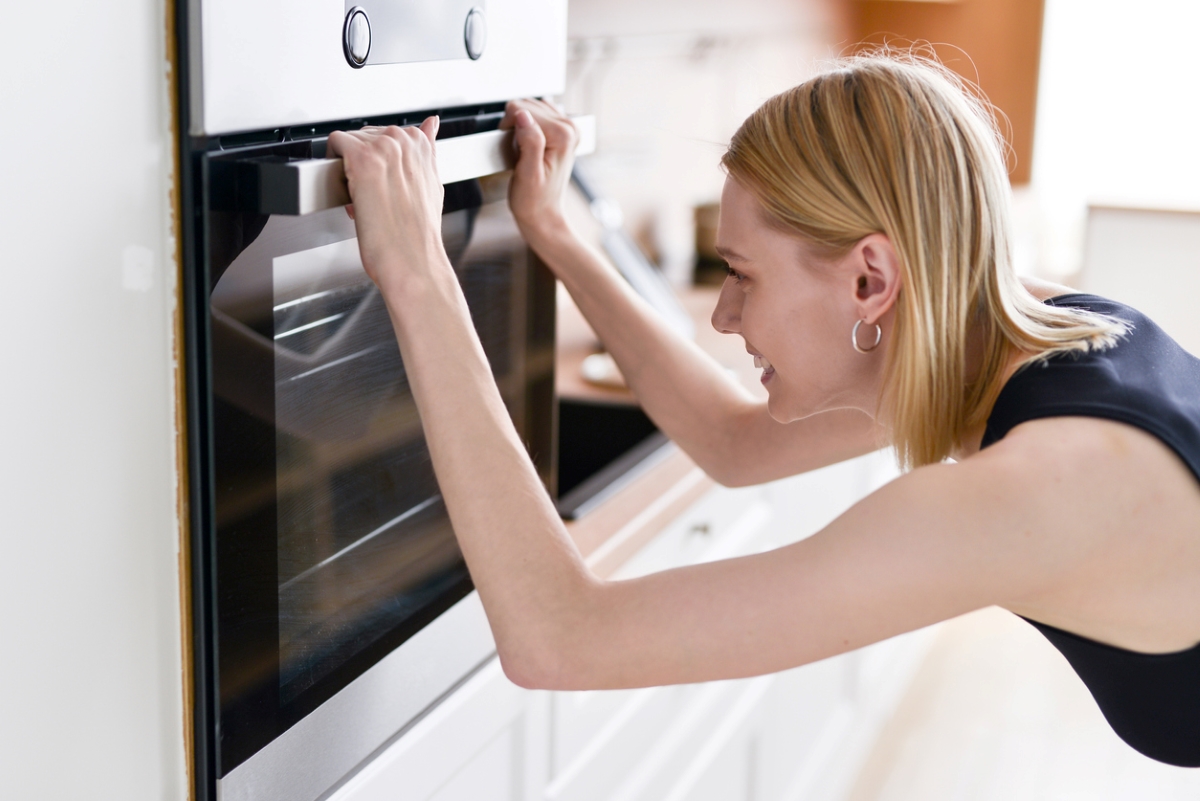 Woman looking at closed oven