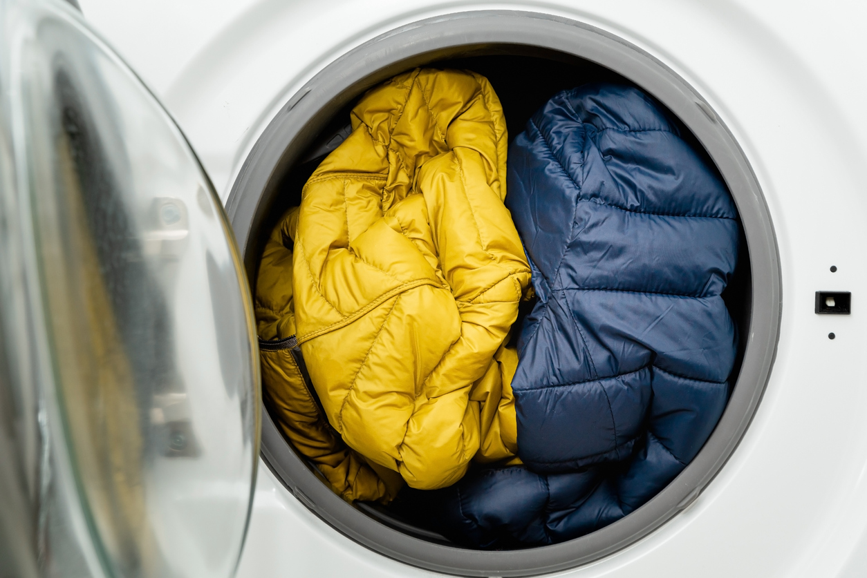 blue and yellow down jackets stuffed into dryer
