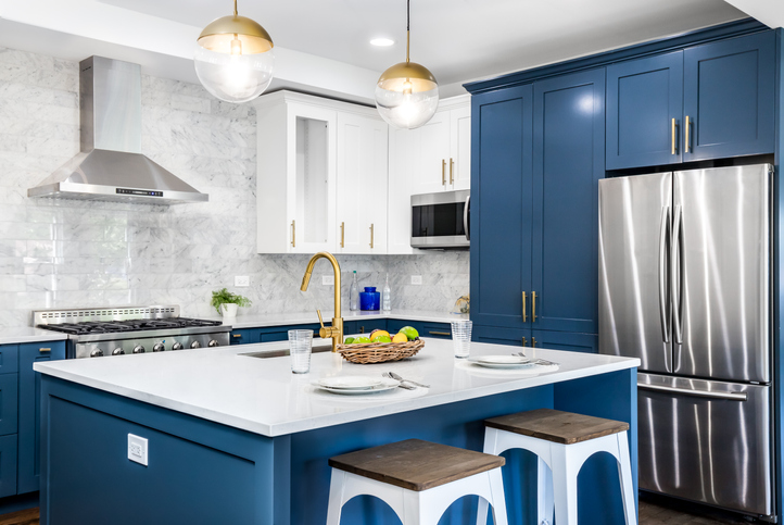 a-kitchen-with-blue-cabinets-and-white-countertops-along-with-staingless-steel-appliances