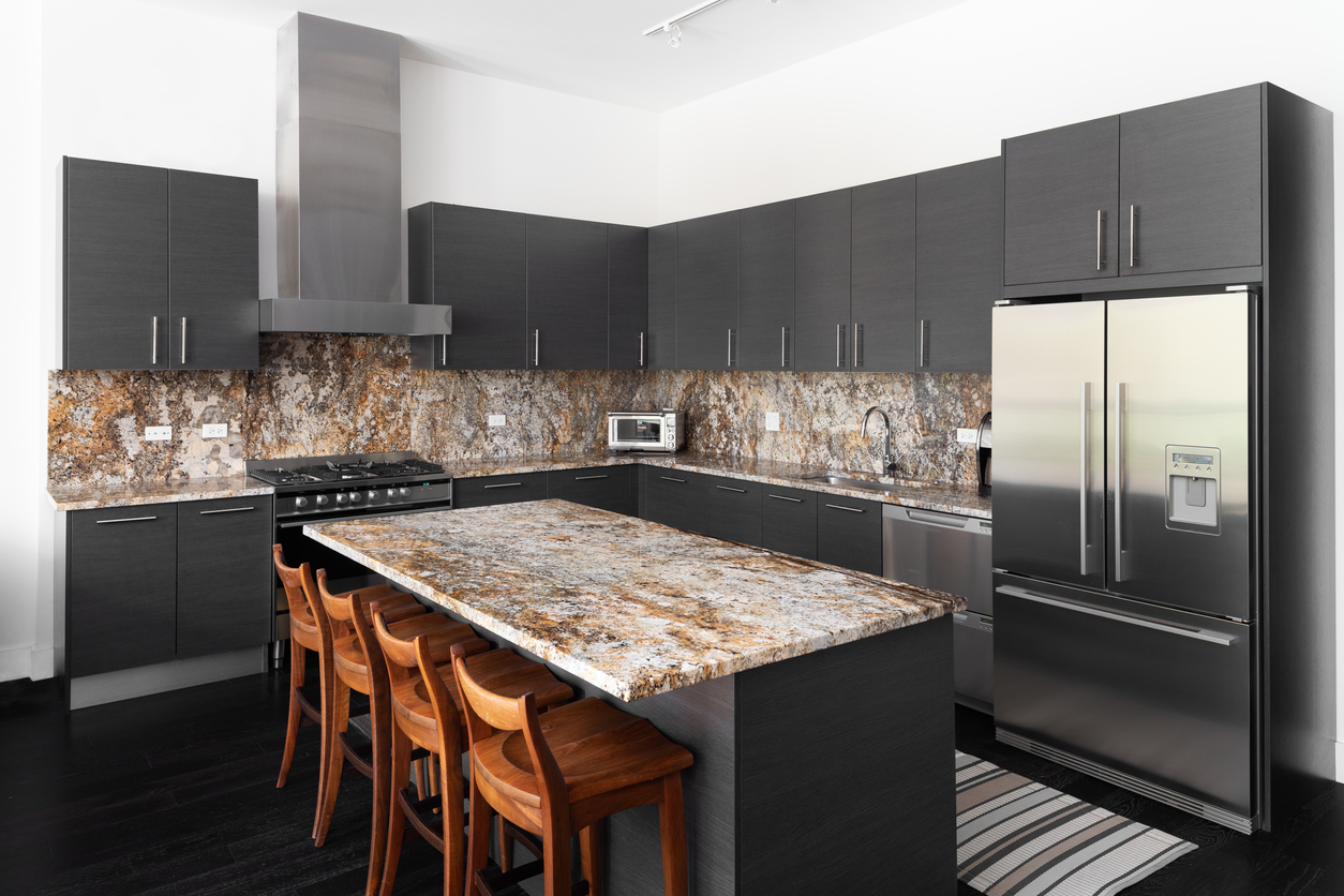 kitchen with dark grey cabinets and brown granite island and countertops
