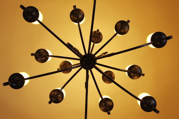 looking-upward-at-a-mid-century-modern-sputnik-light-fixutre-against-a-mustard-yellow-ceiling
