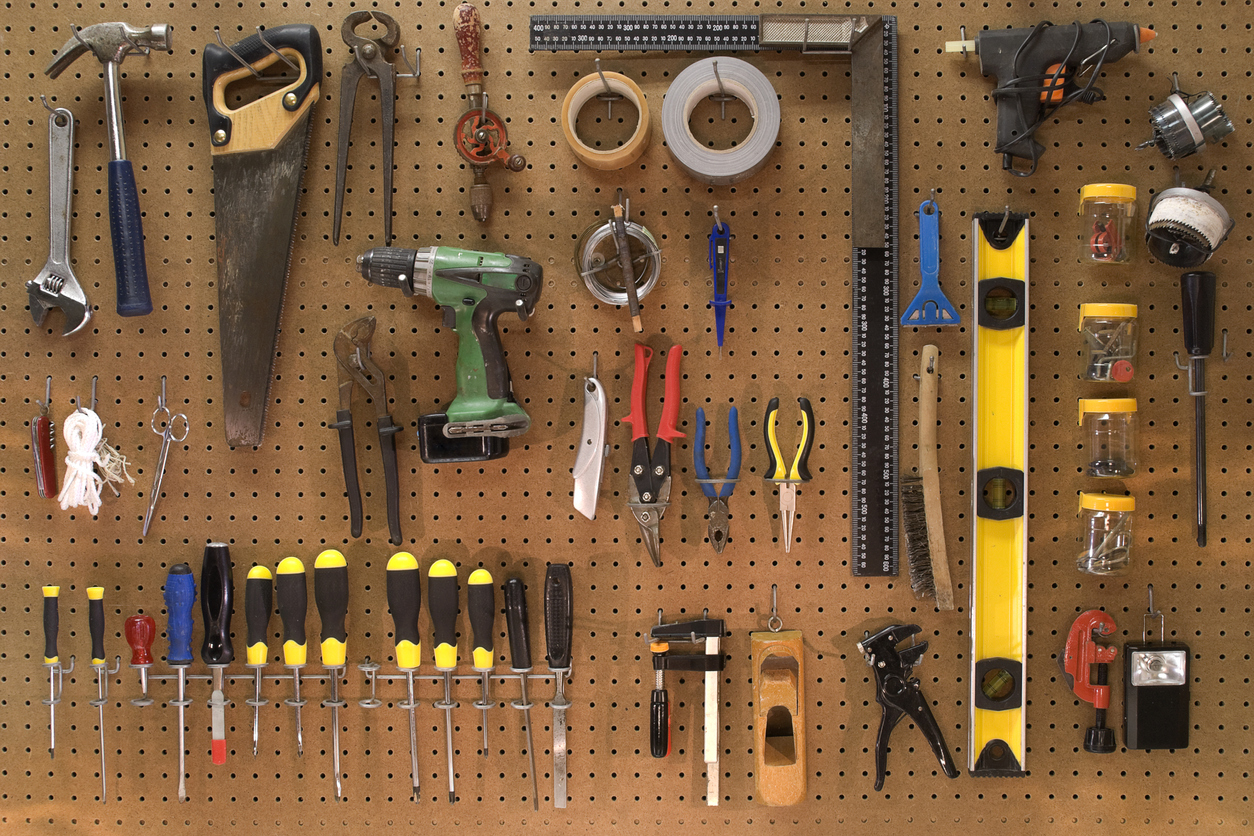 collection of work tools in a workshop mounted on a wall board